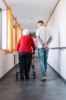 Patiënt en verpleegkundige al wandelend op de gang